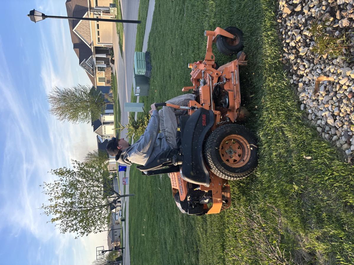 Ryan Ras mowing a lawn in Eastern Iowa